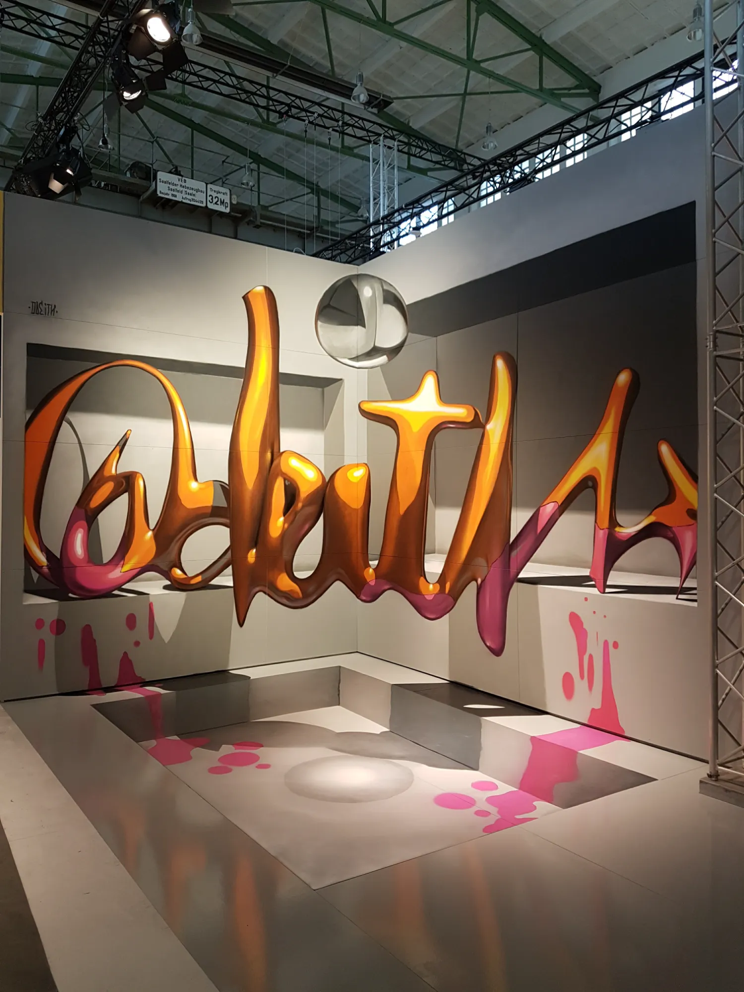 Detail view of the 3D floating lettering mural during the painting process at the Magic City exhibition hall.