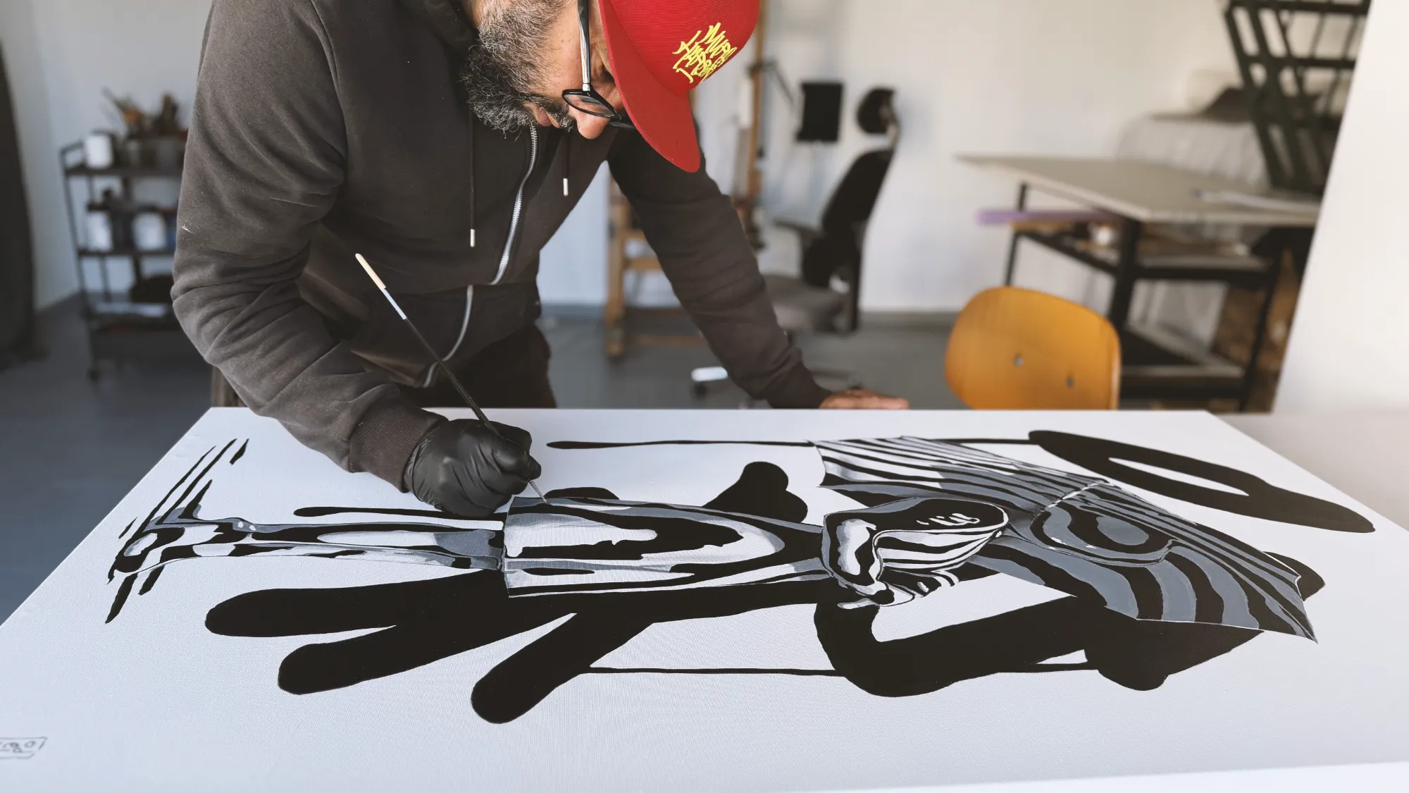 Odeith working on The Space Between Moments, a monochromatic painting featuring a mysterious woman under an umbrella